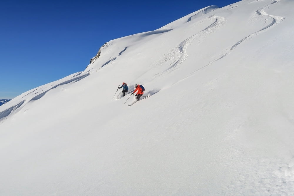 Two people skiing at Alyeska, the resort with the most snow