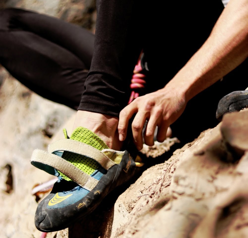 A person putting their foot into a climbing shoe