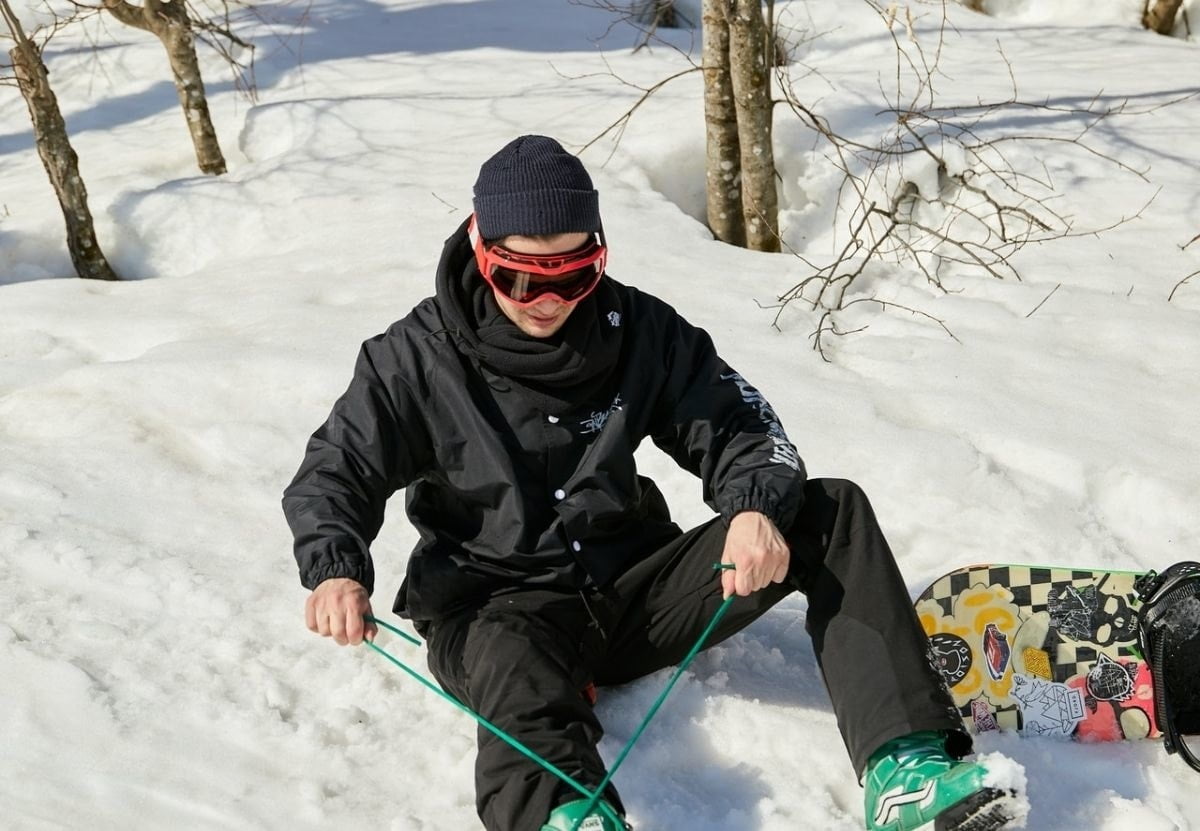 snowboarder-tying-snowboard-boot-laces
