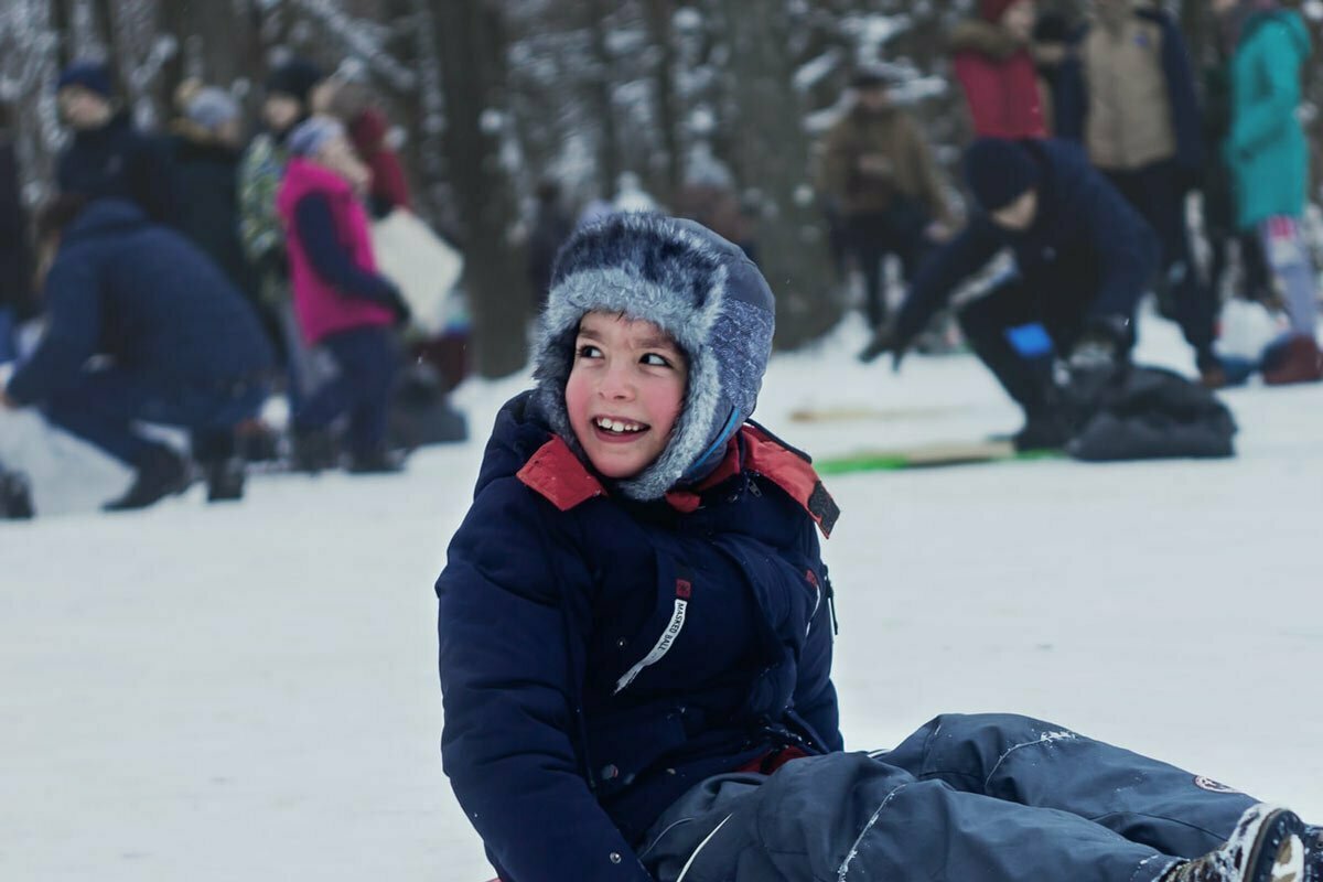 Kid smiling while sitting at snow tubing park